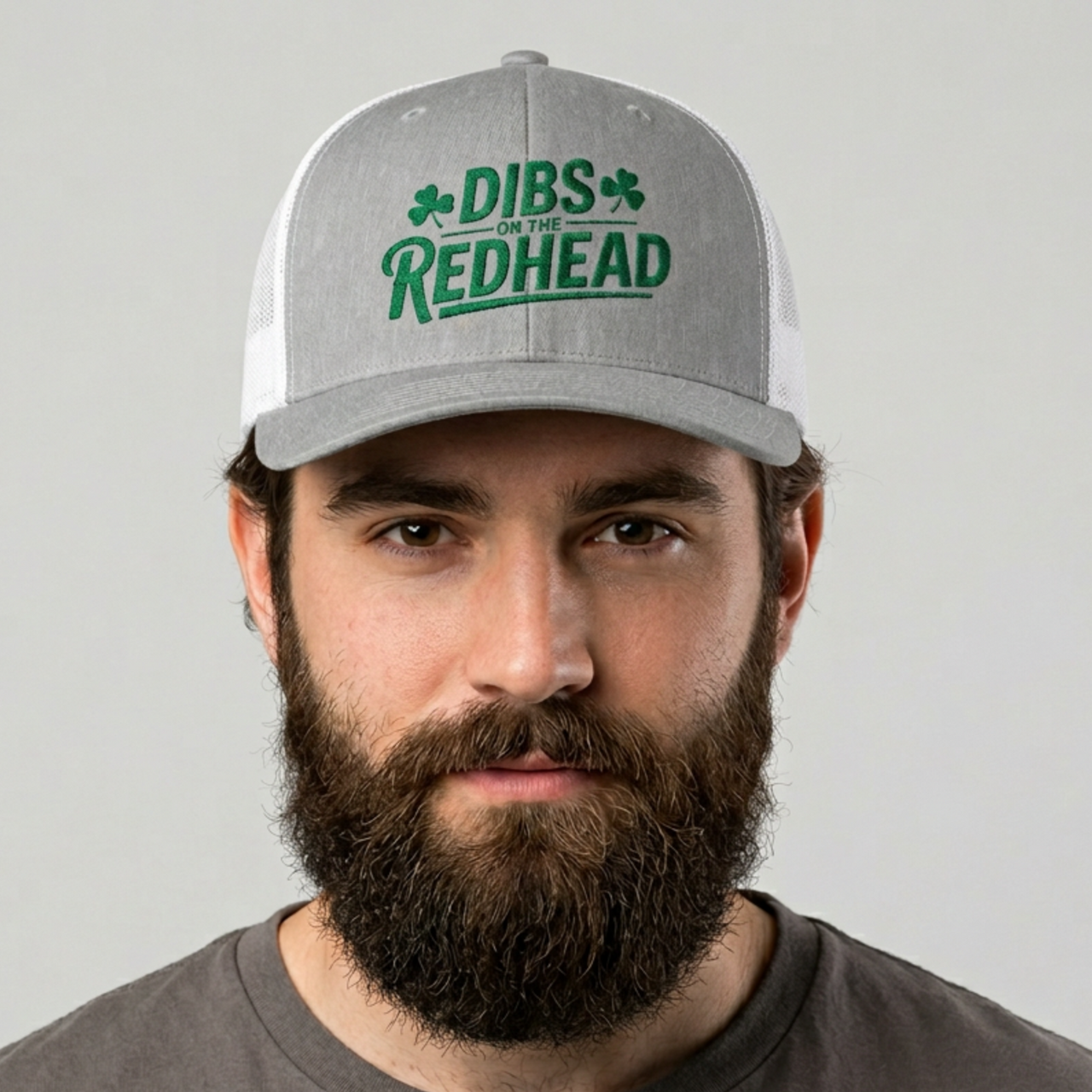 man wearing a gray and white curved bill trucker hat with the text 'DIBS on the REDHEAD' funny st patricks day pub crawl design