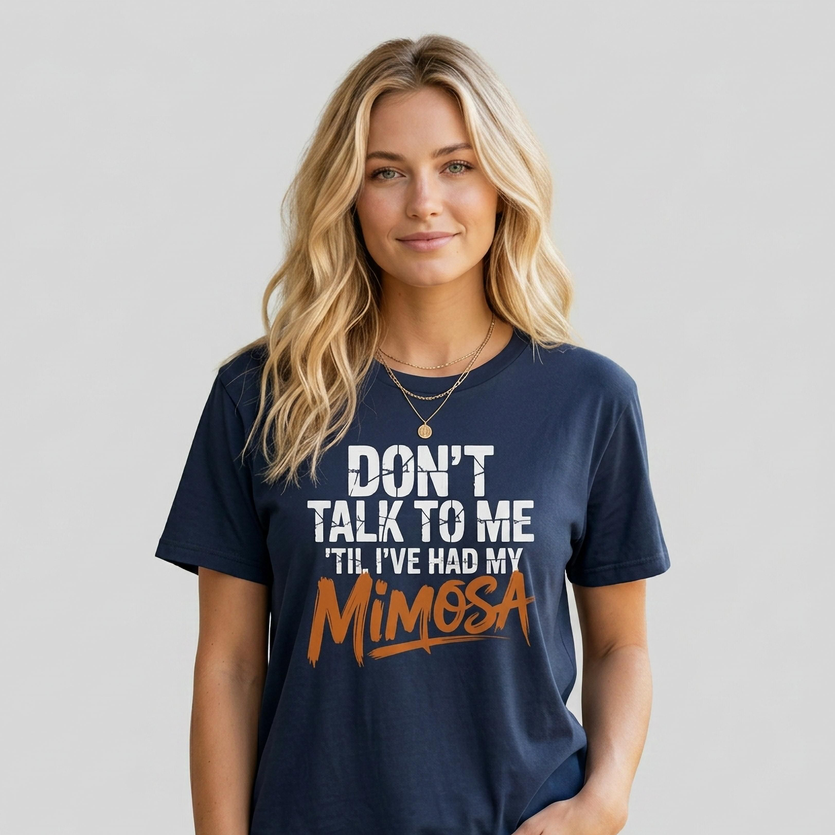 Woman wearing a navy blue premium soft-style t-shirt with text 'DON'T TALK TO ME TIL I'VE HAD MY MIMOSA' funny mom life, mother's day design