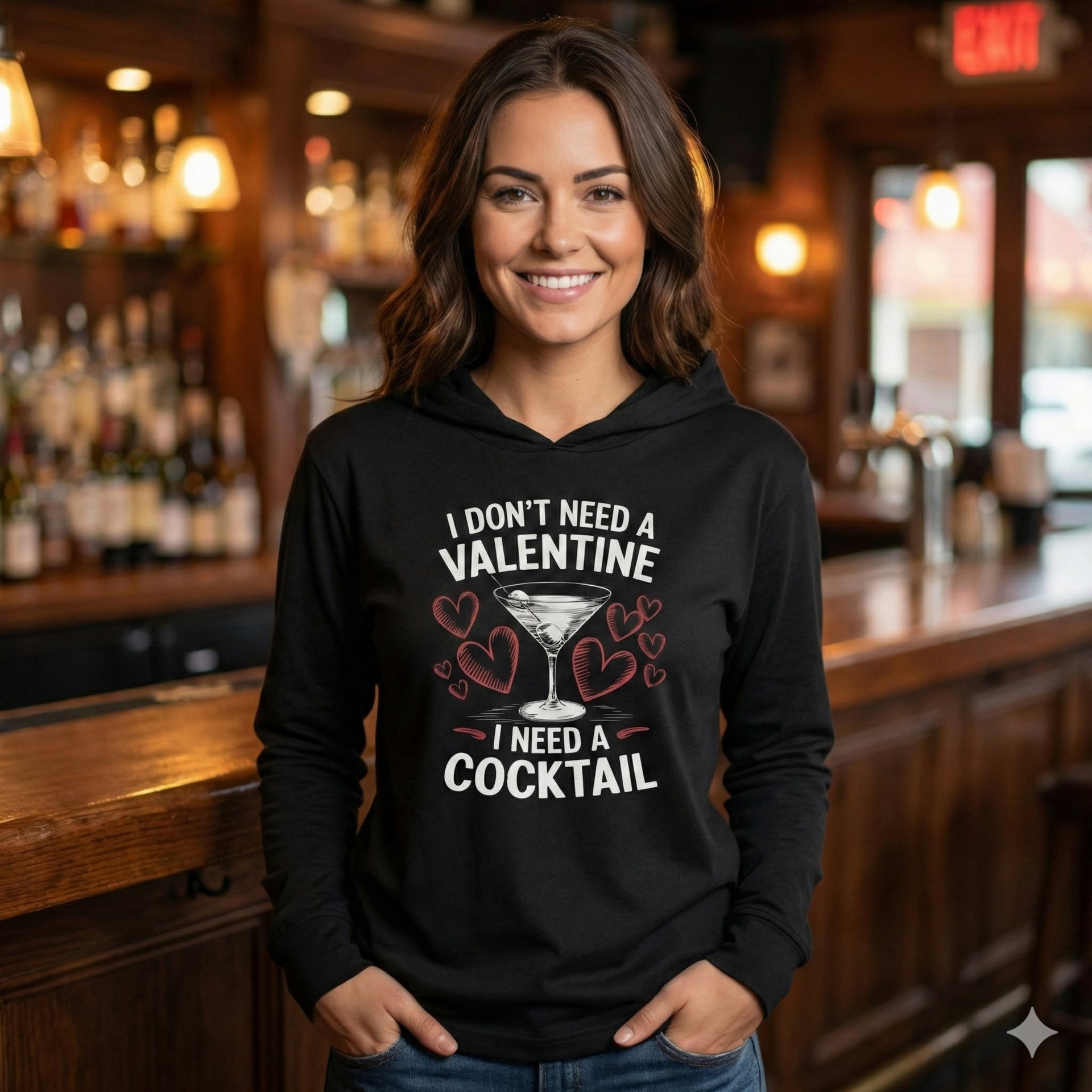 brunette female model wearing black featherweight hoodie with the phrase “I don’t need a valentine I need a cocktail” with an ink sketched wine glass and sketched valentine hearts to  complete the design