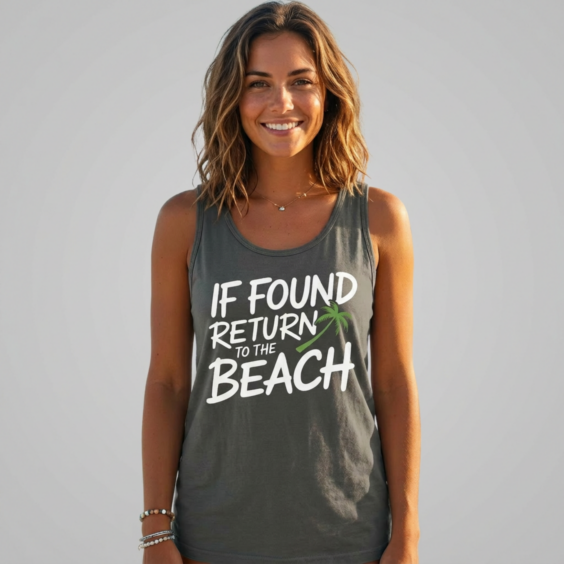 woman wearing a gray tank top with the phrase if found return to the beach funny spring break, girls trip, guys trip, beach trip, summer vacation, and bachelor bachelorette party design