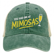 a green and khaki ponytail trucker hat with 'You Had Me at Mimosas' text funny spring break, summer vacation, beach trip, lake season, girls trip or bachelorette had