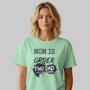 woman wearing a mint green premium soft-style t-shirt with text 'Mom is out of order find dad' funny mother's day, mom life, beach trip design