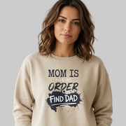 Woman wearing a beige sweatshirt with text 'Mom is out of order, find dad' funny mother's day, mom life, girls trip design