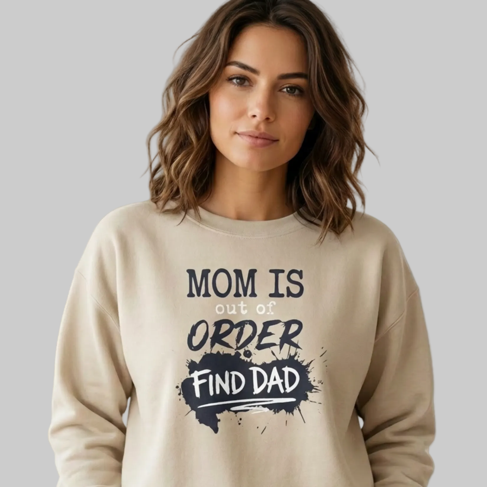 Woman wearing a beige sweatshirt with text 'Mom is out of order, find dad' funny mother's day, mom life, girls trip design