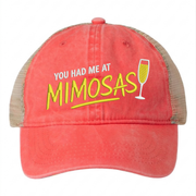 a sherbert and khaki ponytail trucker hat with 'You Had Me at Mimosas' text funny spring break, summer vacation, beach trip, lake season, girls trip or bachelorette had