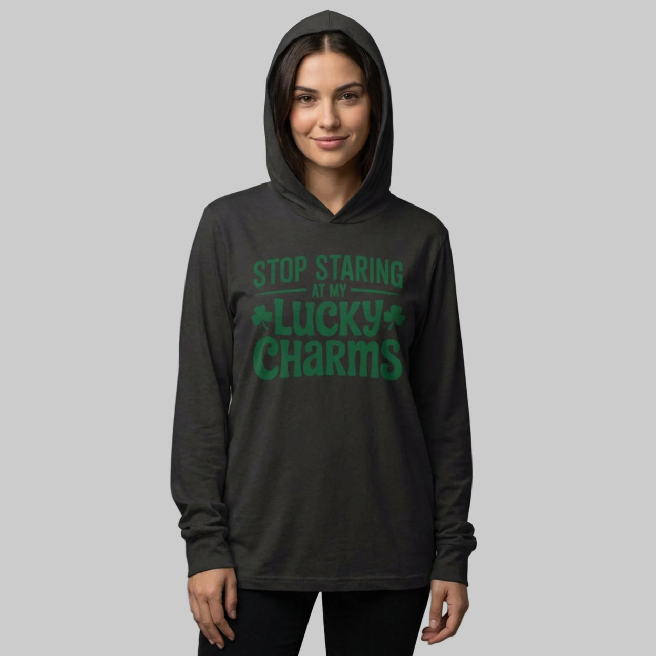 Person wearing a black hoodie with green text "Stop Staring at my lucky charms" on a gray background