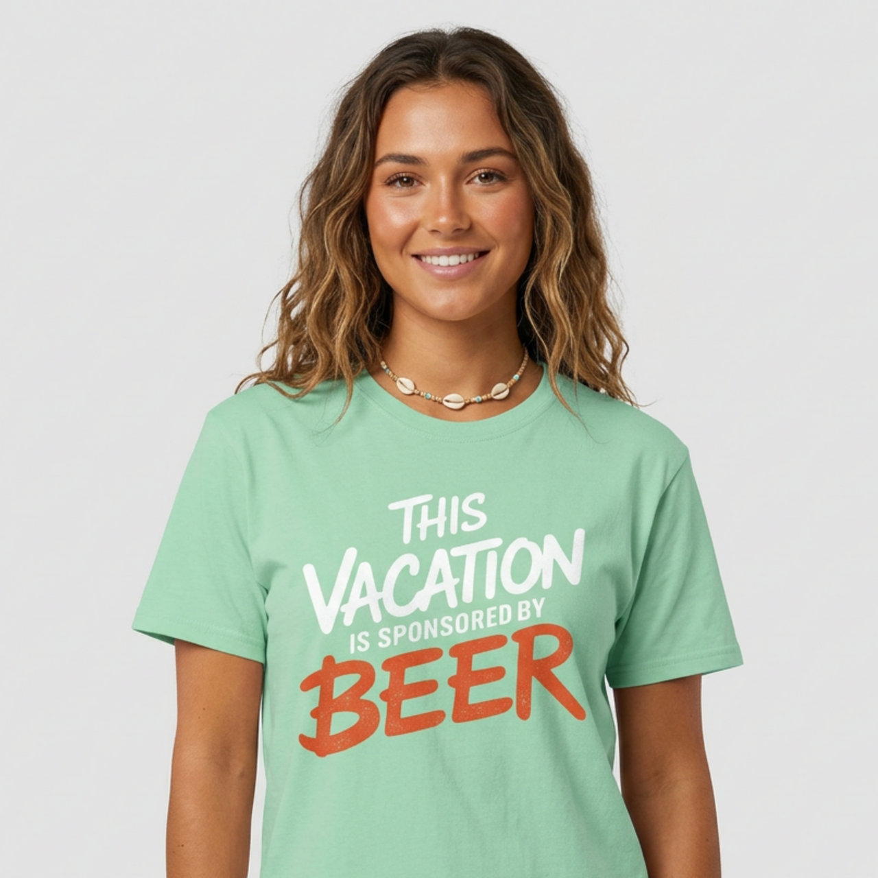 Woman wearing a mint soft-style cotton t-shirt with 'This Vacation is Sponsored by Beer' text funny spring break, beach trip, girls trip, summer vacation design