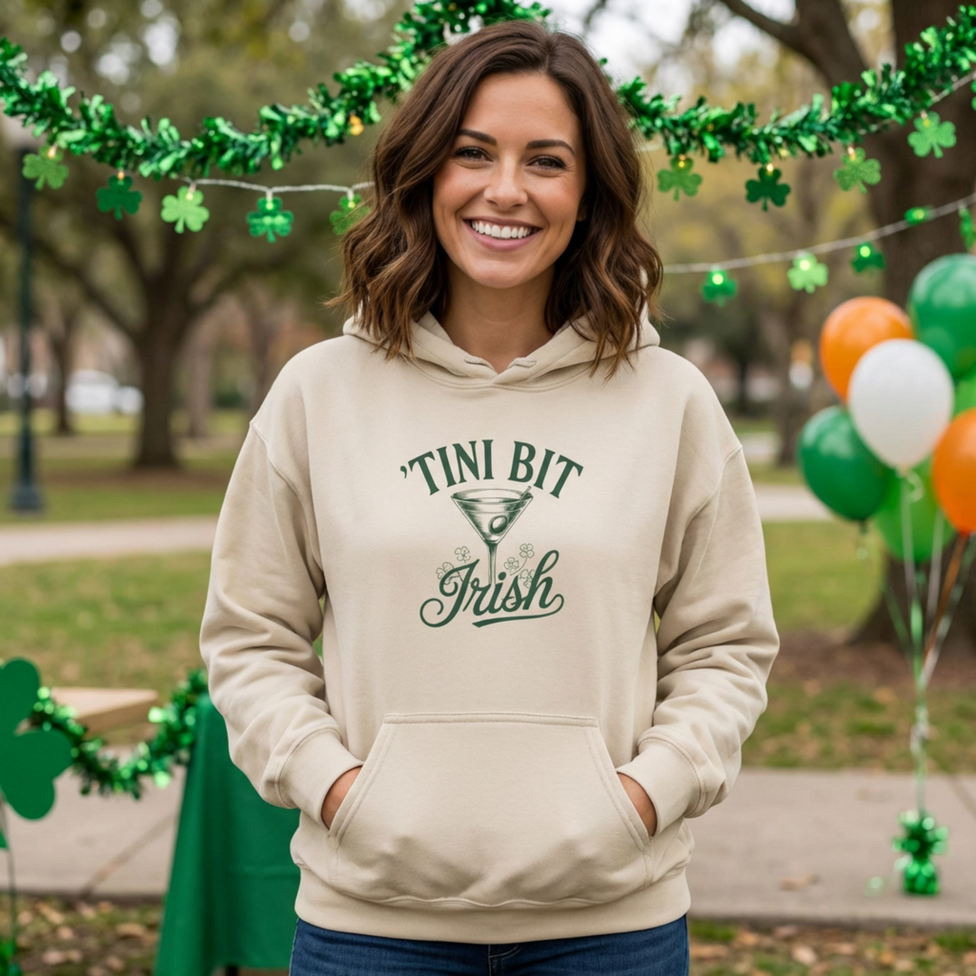 Woman wearing a beige hoodie with 'Tini Bit Irish' and martini glass funny st patricks day hoodie