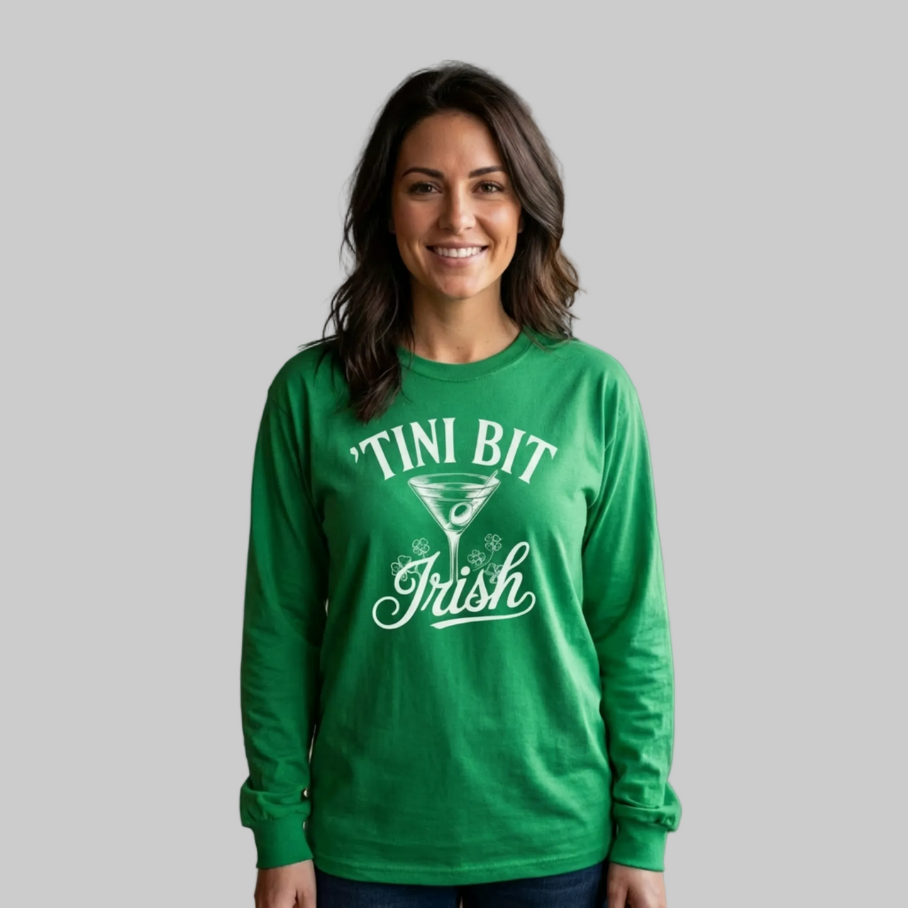 Woman wearing a green long sleeve shirt with 'Tini Bit Irish' text funny st patricks day design