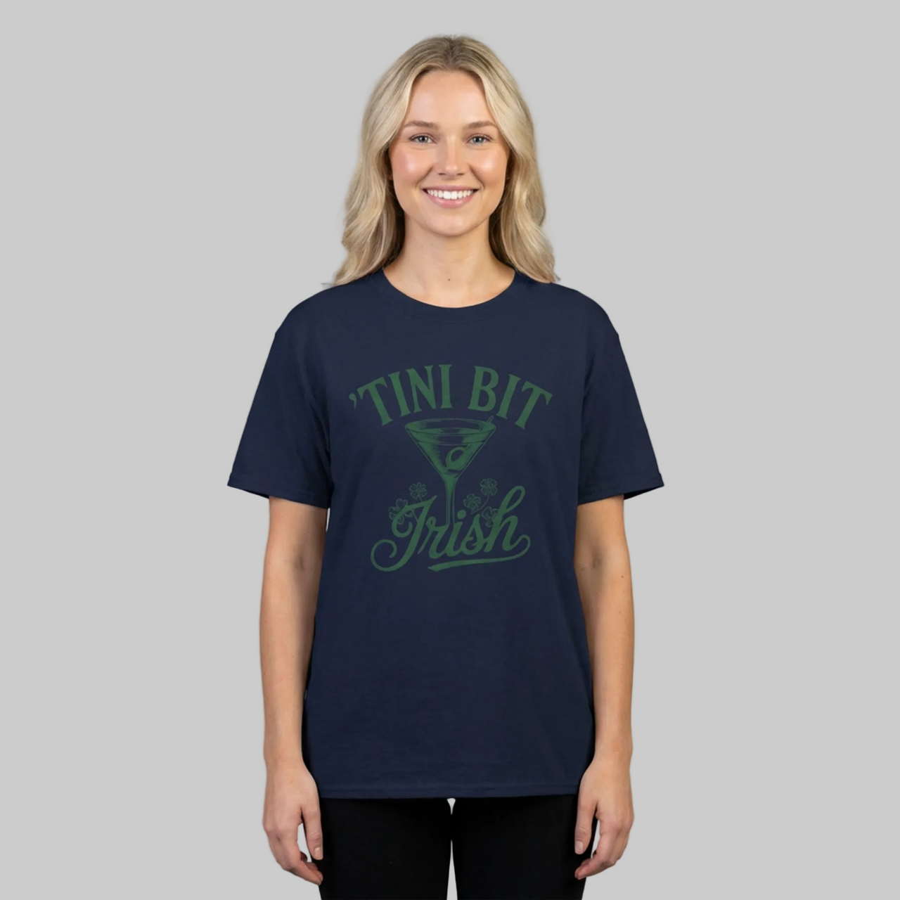 woman wearing a navy blue t-shirt with 'Tini Bit Irish' text and martini glass funny st patricks day design