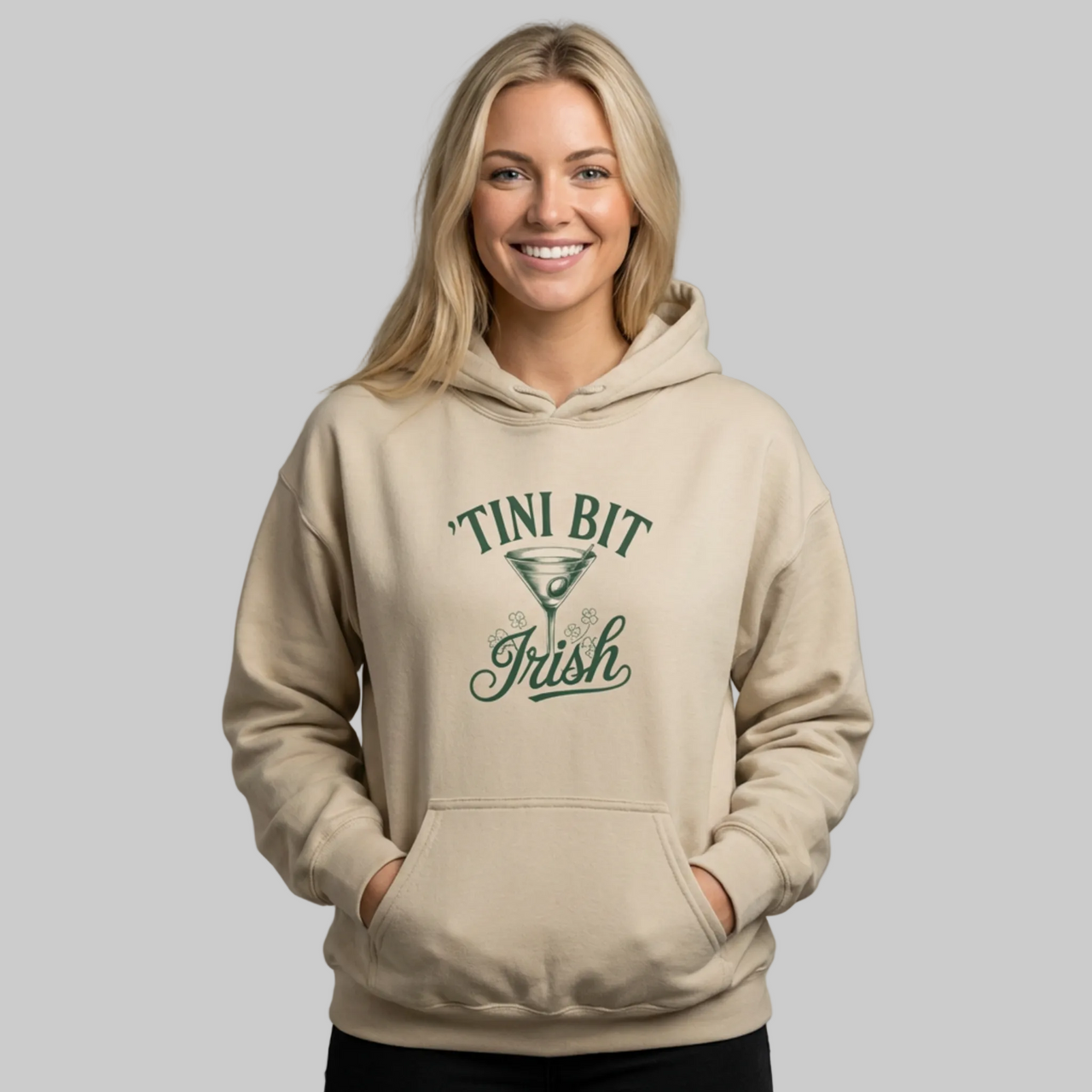 Woman wearing a beige hoodie with 'Tini Bit Irish' and martini glass funny st patricks day hoodie