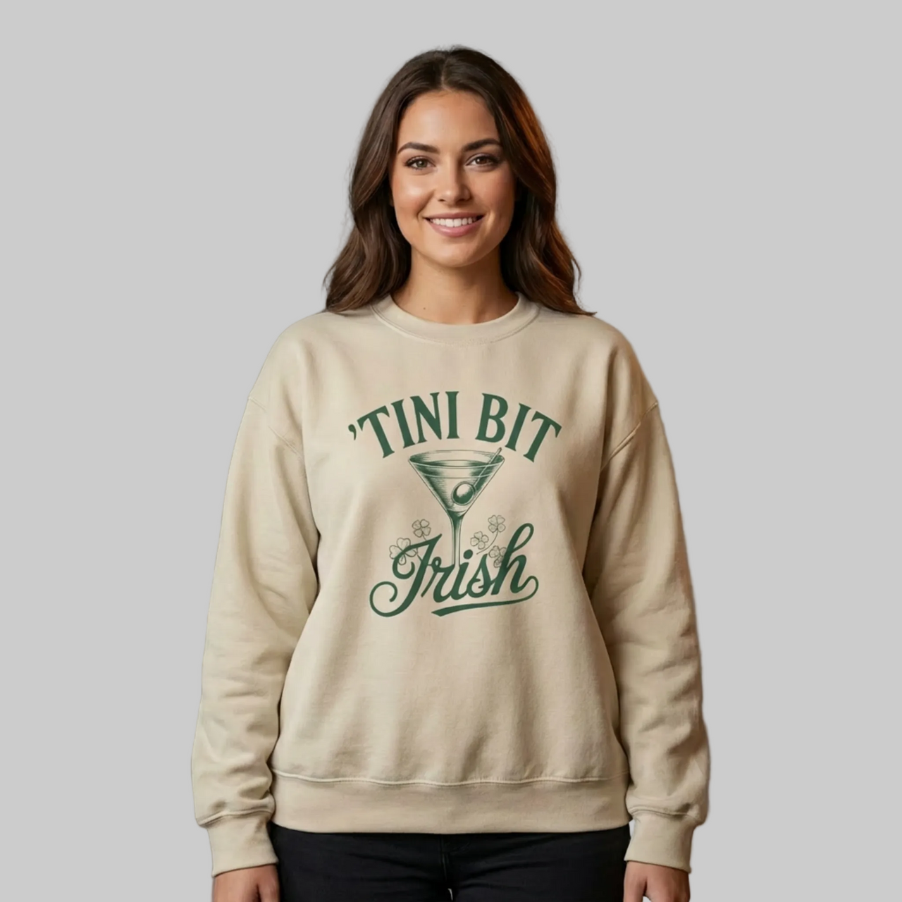 Woman wearing a beige sweatshirt with 'TINI BIT IRISH' text funny st patricks day design