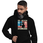 4th of July Hoodie with '100% American Drunkard' text, man drinking a bottle of beer wearing a trucker hat, and distressed American flag background