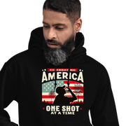 Hoodie with Celebrating America One Shot at a Time text, silhouette of a man drinking a shot, and distressed American flag background. Perfect for 4th of July.