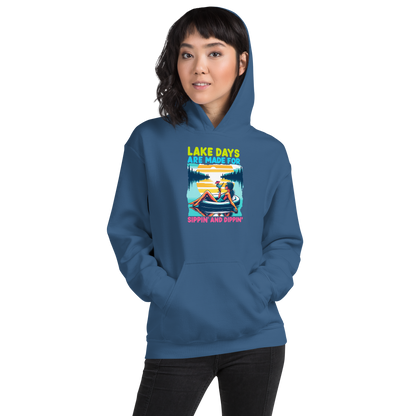 Hoodie with "Lake Days Are Made for Sipping and Dipping," showing a woman on a tube float with a cocktail, lake and sunset scene.