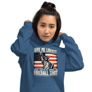 Hoodie with 'Give Me Liberty or Give Me a Fireball Shot' text, Statue of Liberty holding a shot glass, and distressed American flag background. Perfect for 4th of July.