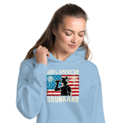 4th of July Hoodie with '100% American Drunkard' text, man drinking a bottle of beer wearing a trucker hat, and distressed American flag background