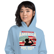 Hoodie with Celebrating America One Shot at a Time text, silhouette of a man drinking a shot, and distressed American flag background. Perfect for 4th of July.