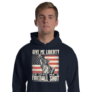 Hoodie with 'Give Me Liberty or Give Me a Fireball Shot' text, Statue of Liberty holding a shot glass, and distressed American flag background. Perfect for 4th of July.