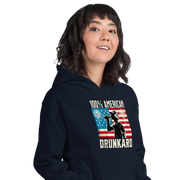 4th of July Hoodie with '100% American Drunkard' text, man drinking a bottle of beer wearing a trucker hat, and distressed American flag background