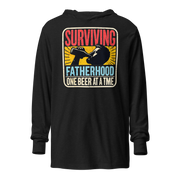 Celebrate fatherhood with our "Surviving Fatherhood One Beer at a Time" lightweight hoodie. Perfect gift for dads on Father's Day or any occasion.