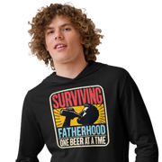 Celebrate fatherhood with our "Surviving Fatherhood One Beer at a Time" lightweight hoodie. Perfect gift for dads on Father's Day or any occasion.