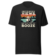 Tee showing "I Come to the Lake for the Views and Stay for the Booze," with a man in a beach chair, lake, and retro sunset.