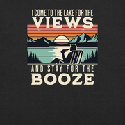 Tee showing "I Come to the Lake for the Views and Stay for the Booze," with a man in a beach chair, lake, and retro sunset.