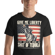 T-shirt with Give Me Liberty or Give Me a Shot of Tequila text, Statue of Liberty holding a shot glass, and distressed American flag background. Perfect for 4th of July.