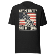 T-shirt with Give Me Liberty or Give Me a Shot of Tequila text, Statue of Liberty holding a shot glass, and distressed American flag background. Perfect for 4th of July.