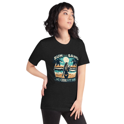 Woman with cocktail on beach on 'Sun, Sand, and a Drink in My Hand' tee, showcasing ocean and sun background