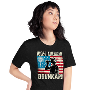 4th of July T-shirt with '100% American Drunkard' text, man drinking a bottle of beer wearing a trucker hat, and distressed American flag background