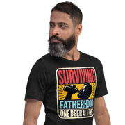 Celebrate fatherhood with our "Surviving Fatherhood One Beer at a Time" t-shirt. Perfect gift for dads who love a cold one. Ideal for Father's Day or birthdays.