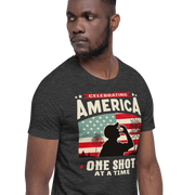 T-shirt with Celebrating America One Shot at a Time text, silhouette of a man drinking a shot, and distressed American flag background. Perfect for 4th of July.