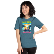 Tee with "Lake Days Are Made for Sipping and Dipping," featuring a woman on a tube float with a cocktail, lake and sunset backdrop.