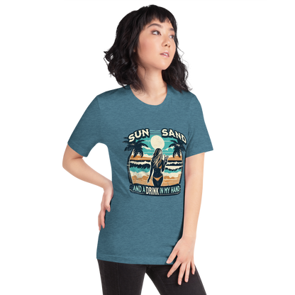 Woman with cocktail on beach on 'Sun, Sand, and a Drink in My Hand' tee, showcasing ocean and sun background