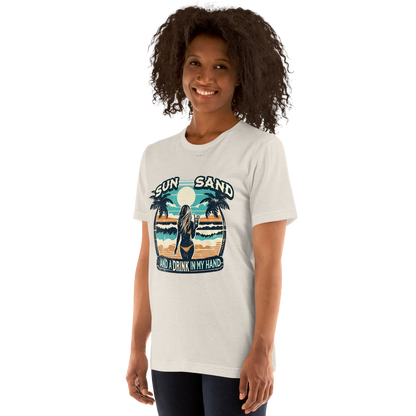 Woman with cocktail on beach on 'Sun, Sand, and a Drink in My Hand' tee, showcasing ocean and sun background