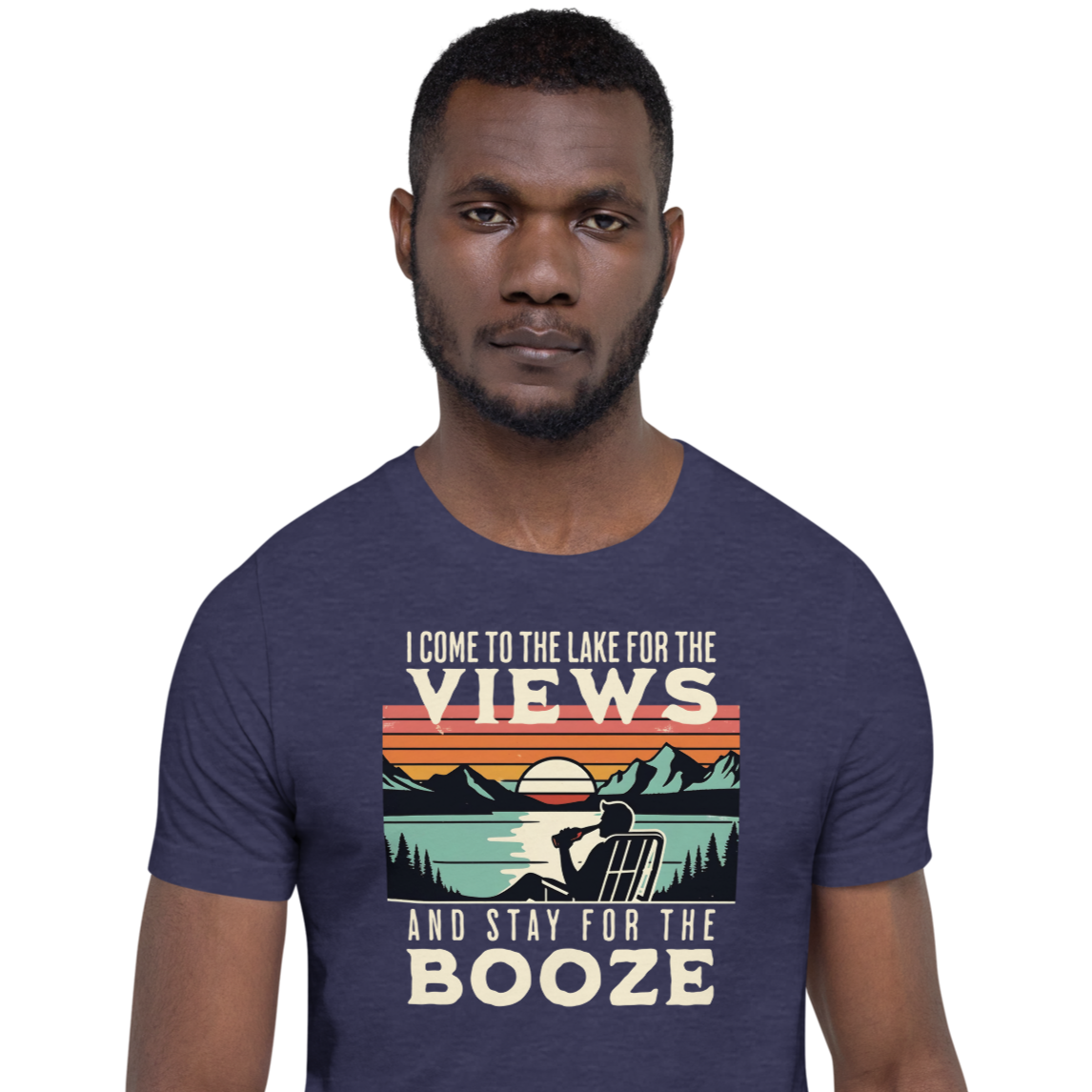 Tee showing "I Come to the Lake for the Views and Stay for the Booze," with a man in a beach chair, lake, and retro sunset.