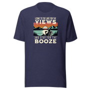 Tee showing "I Come to the Lake for the Views and Stay for the Booze," with a man in a beach chair, lake, and retro sunset.