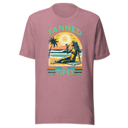 Vintage-inspired 'Tanned and Tipsy' tee with a woman sipping a cocktail on a beach at sunset, perfect for beach drinking and summer parties.