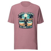 Woman with cocktail on beach on 'Sun, Sand, and a Drink in My Hand' tee, showcasing ocean and sun background