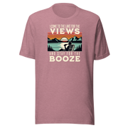 Tee showing "I Come to the Lake for the Views and Stay for the Booze," with a man in a beach chair, lake, and retro sunset.