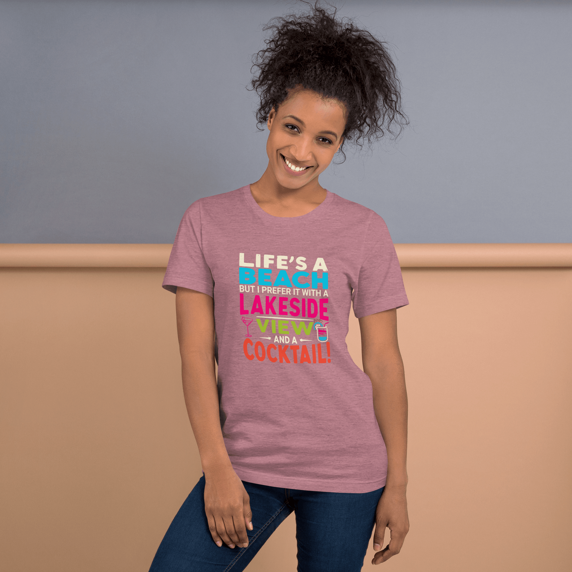 Tee displaying "Life's a Beach but I Prefer It with a Lakeside View and a Cocktail" in bright, eye-catching colors.