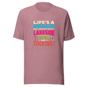 Tee displaying "Life's a Beach but I Prefer It with a Lakeside View and a Cocktail" in bright, eye-catching colors.