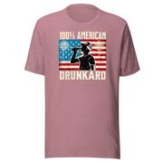 4th of July T-shirt with '100% American Drunkard' text, man drinking a bottle of beer wearing a trucker hat, and distressed American flag background