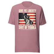 T-shirt with Give Me Liberty or Give Me a Shot of Tequila text, Statue of Liberty holding a shot glass, and distressed American flag background. Perfect for 4th of July.