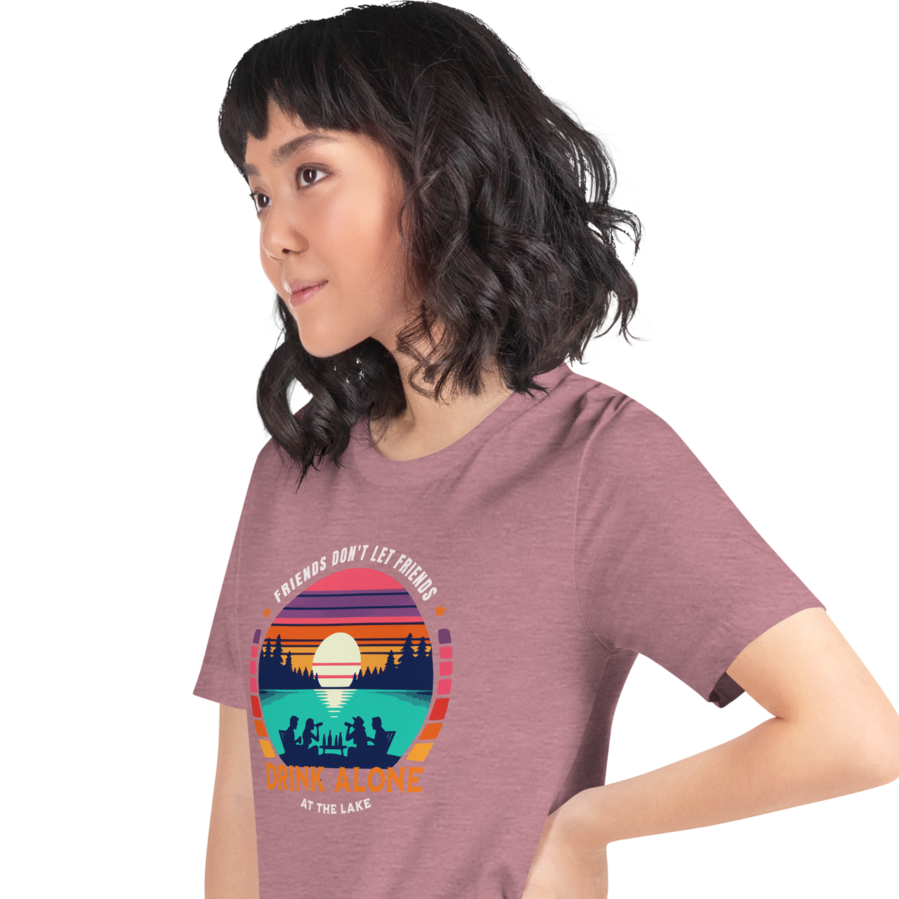 Tee showcasing "Friends Don't Let Friends Drink Alone at the Lake" with a retro sunset and lake scene.