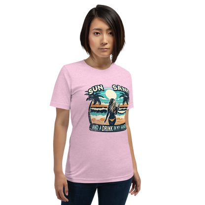 Woman with cocktail on beach on 'Sun, Sand, and a Drink in My Hand' tee, showcasing ocean and sun background