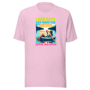 Tee with "Lake Days Are Made for Sipping and Dipping," featuring a woman on a tube float with a cocktail, lake and sunset backdrop.