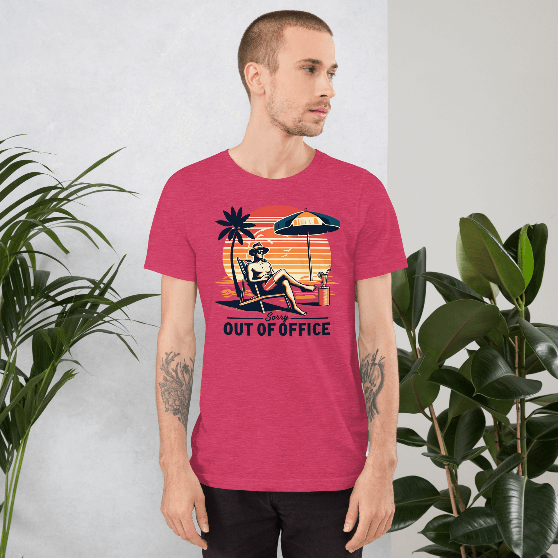 Man lounging in a beach chair with a cocktail, wearing our 'Sorry, Out of Office' vintage tee against a retro sunset backdrop.